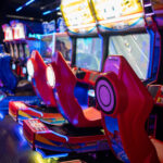 Gaming chairs in illuminated arcade game zone in shopping mall