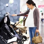 Pregnant woman looking at strollers