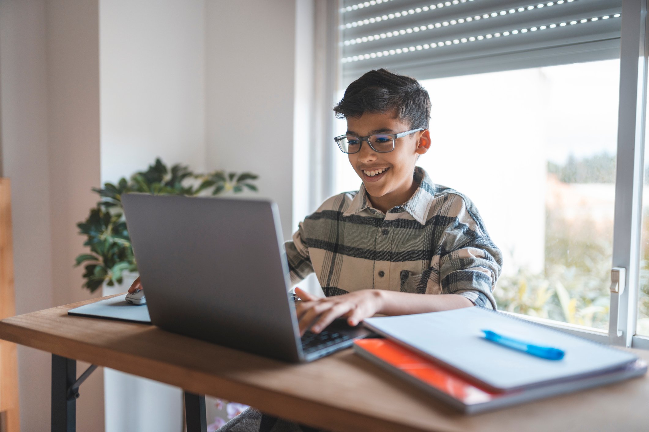 Boy using laptop studying online at home