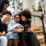 Friends using the mobile phone outdoors