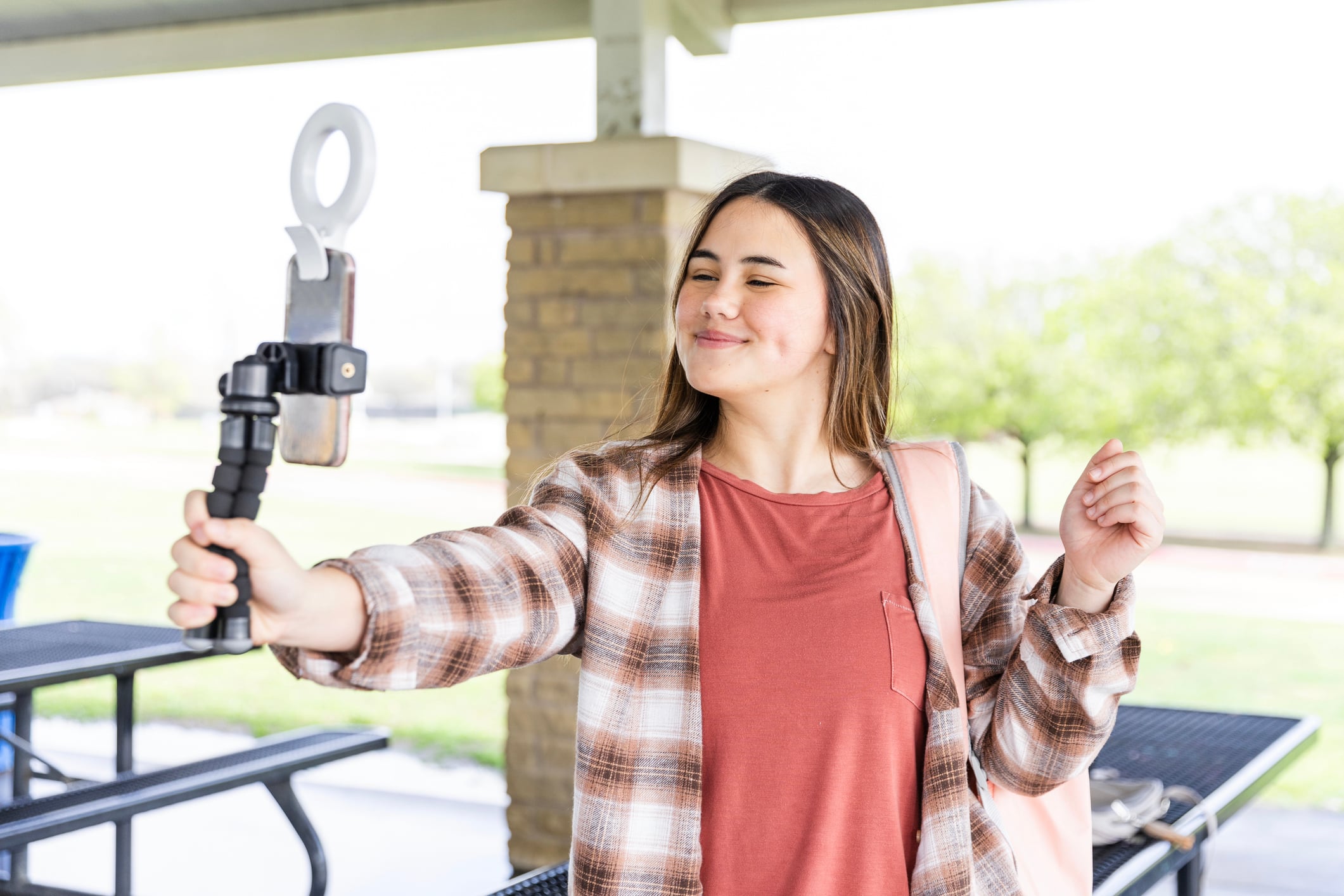 Teenage girl takes selfie using phone with ring light