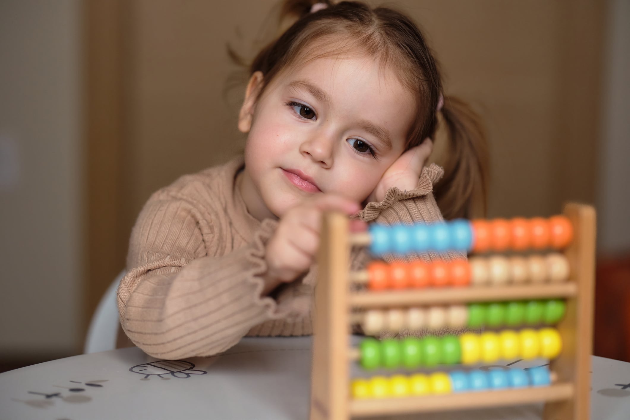Cute little girl learning how to count on abacus toy